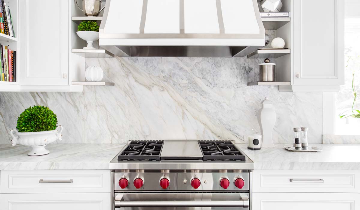 white and gray marble backsplash behind stove in kitchen